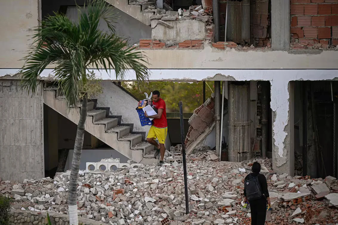a-man-carries-belongings-out-of-a-damaged-Y5GLVMPLRVBMPCVGOX7GLEGBOA